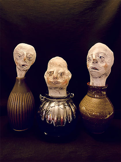 Sculpture heads emerging from ceramic pots